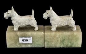 Pair of Art Deco Cold Painted Metal Highland Terrier Book Ends, raised on marble bases.