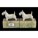 Pair of Art Deco Cold Painted Metal Highland Terrier Book Ends, raised on marble bases.