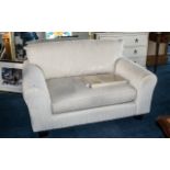 Two Seater Contemporary Overstuffed Sofa, covered in an ivory coloured material, on square feet.