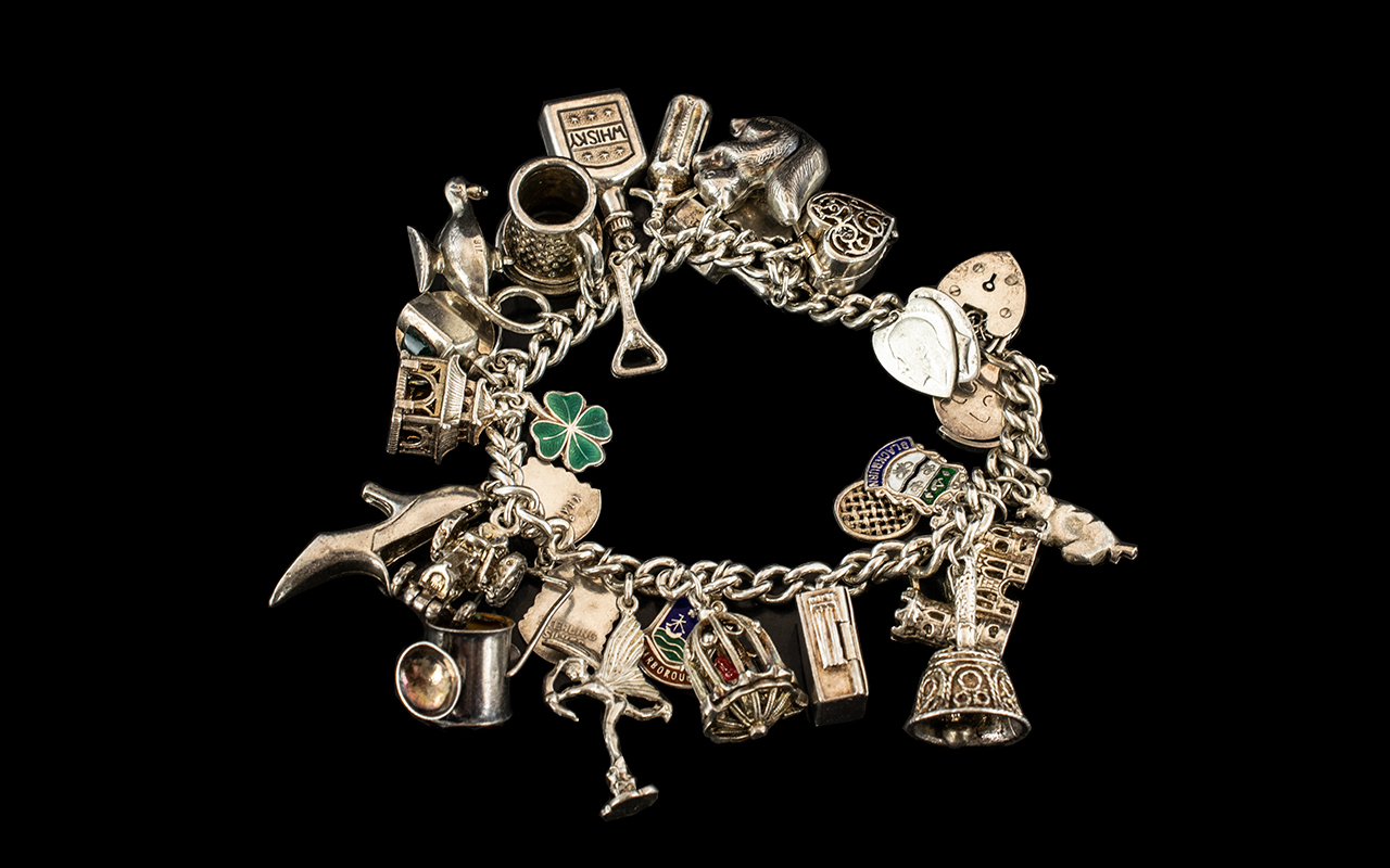 A Vintage Sterling Silver Charm Bracelet Loaded with 25 Silver Charms.