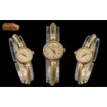 A Ladies 9ct Gold Omega Wrist Watch, champagne dial with baton and Arabic numerals. Manual wind.