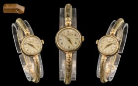 A Ladies 9ct Gold Omega Wrist Watch, champagne dial with baton and Arabic numerals. Manual wind.