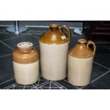 Three Stoneware Demijohns, with brown glazed tops, measuring 17", 14" and 12" tall.