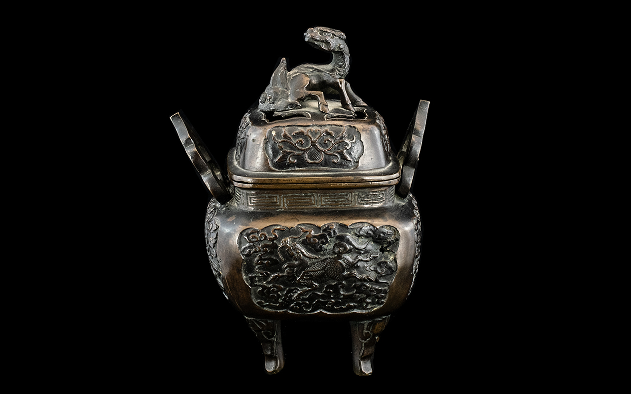 A Chinese Bronze Sensor, twin handled the cover with stylised dragon. Height 7".