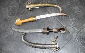 Two Middle Eastern Antique Daggers in brass and copper embossed sheaths,