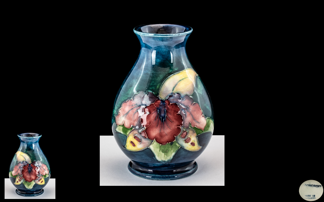 A Small Moorcroft Vase Orchid design on a blue ground. Height 3 1/2 inches.