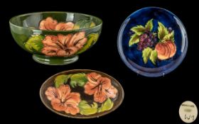 Three Pieces of Moorcroft to include a small Hibiscus Shallow Bowl on a green ground 6 inches,