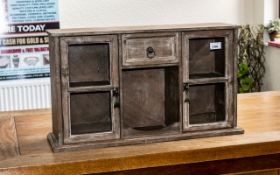 Small Wooden Display Cabinet with two cupboard doors with glass fronts, and a central drawer above a