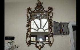 Ornate Gilt Framed Mirror with scroll and crest design. 21" wide.