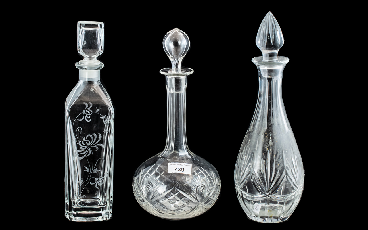 Three Decorative Glass Decanters, one in square form 13" tall with etched decoration,