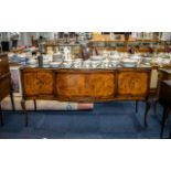 A 1980's Walnut and Mahogany Side table with glass top protector serpentine front with four doors