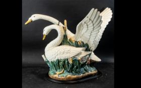 Spanish Porcelain Swans Group, depicting two swans, one with raised wings, mounted on a wooden base.
