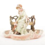 A Continental porcelain centrepiece of a lady seated on a bench
