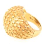 A yellow metal domed dress ring marked 18K