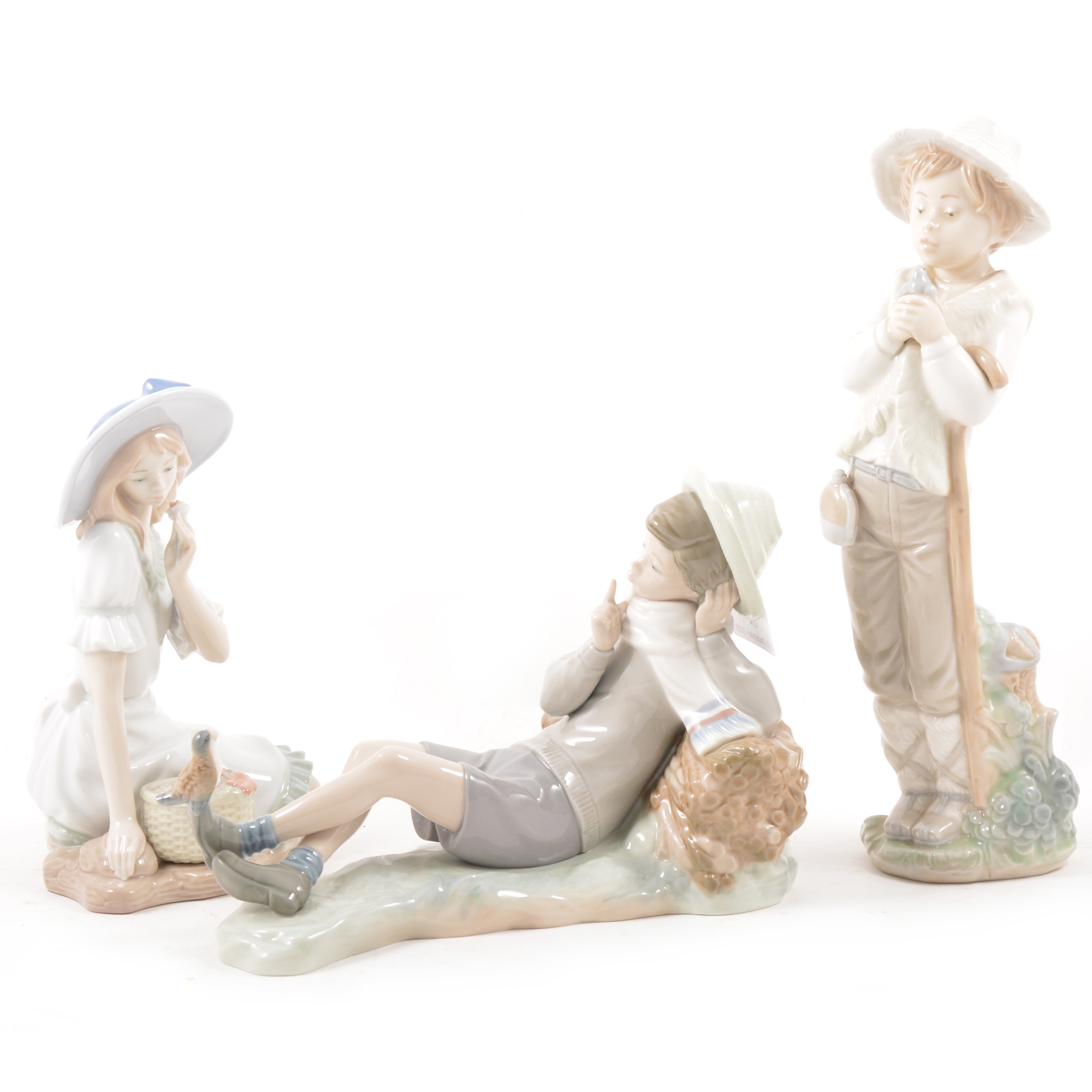 A Lladro porcelain figure and two Nao porcelain figures