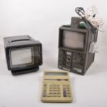Two vintage portable televisions and a calculator.