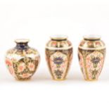 A pair of Royal Crown Derby Imari design miniature ovoid vases, and a miniature swollen vase.