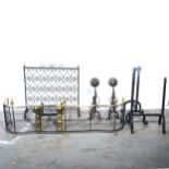 A brass and wire fender, two pairs of fire dogs, wrought iron screen, and a fire basket stand.