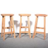 Three modern hardwood counter stools.