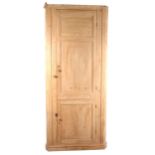 A tall freestanding pine corner cupboard.