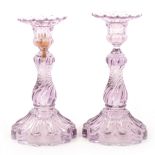 A pair of amethyst-coloured moulded glass candlesticks.