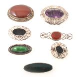 Seven silver and white metal stone set brooches.