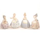 A set of four small Lladro figures of girls.