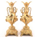 A pair of brass pricket candlesticks with cherubs