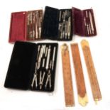 A quantity of cased drawing instruments, folding yardsticks and rules.