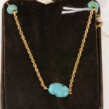 Yellow metal necklace with seven turquoise matrix beads.