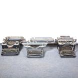 Cast iron doorstop and three vintage typewriters,