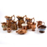 Collection of copper lustre jugs and related items.
