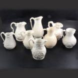 Eight assorted Victorian Parian relief-moulded jugs