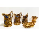 Collection of copper lustre jugs and related items.
