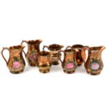 Quantity of copper lustreware jugs.