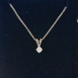 A diamond single stone pendant and chain.