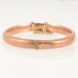 A 9 carat rose gold half hinged bangle.