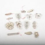 Fourteen vintage paste set brooches and dress clips set with large brilliants.