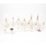 Eighteen cut glass scent bottles and one dressing table pot, many with silver collars.