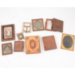 A collection of daguerreotype and later portrait photographs in frames and folding cases.