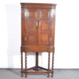 Joined oak corner cupboard on a stand,