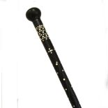 A lignum vitae walking cane with inlaid stud work.,