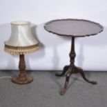 Stained mahogany pedestal table, another adapted pedestal table, and a table lamp