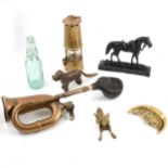 A box of objects, including bottles, miners lamp, dog nut cracker, fox door knocker, etc.