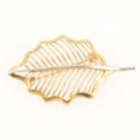 A 750 leaf design brooch.