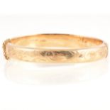 A 9 carat yellow gold half hinged bangle.