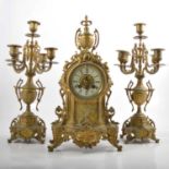 A three piece French style brass clock garniture, and candelabra.
