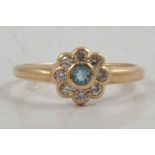 A synthetic stone and cubic zirconia daisy cluster ring.