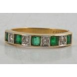 An emerald and diamond half eternity ring.