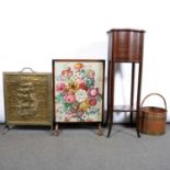 A mahogany plant stand, two fire screens, one a brass galleon, one embroidered, copper bucket.